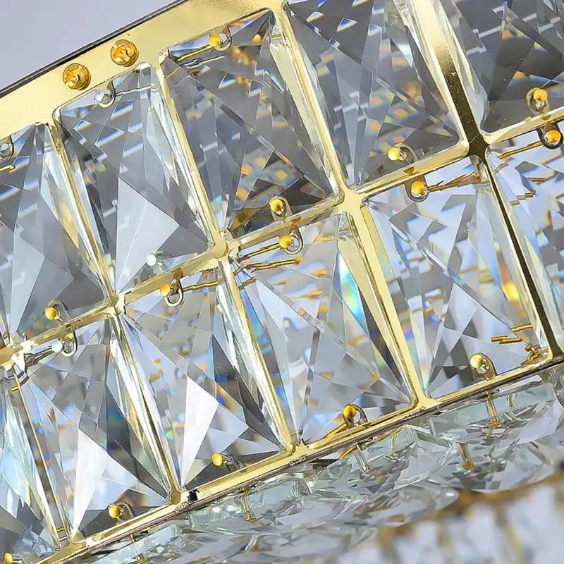 A luxurious gold-toned decorbites crystal chandelier pendant light with faceted crystals in a geometric grid pattern