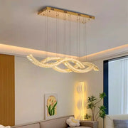 Gold-toned decorbites crystal chandelier pendant light with modern flowing crystals emitting warm ambient light for living room