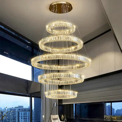A multi-tiered decorbites crystal chandelier pendant light with cascading crystal rings and gold-toned ceiling mount