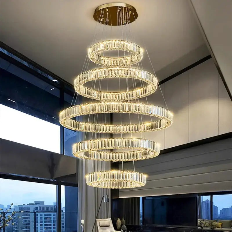 A multi-tiered decorbites crystal chandelier pendant light with cascading crystal rings and gold-toned ceiling mount