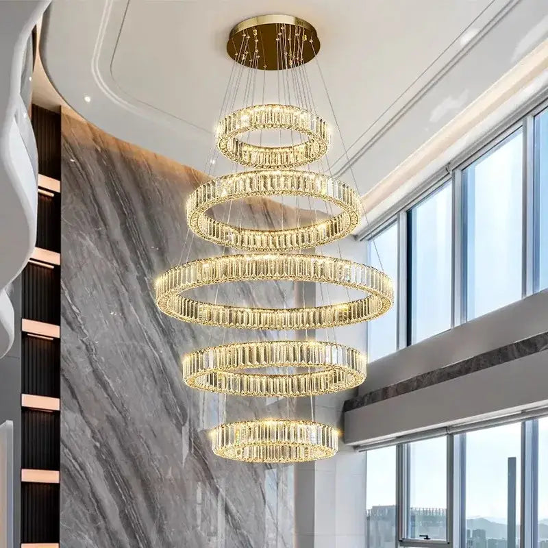 A multi-tiered decorbites crystal chandelier pendant light with cascading golden rings and clear crystal elements for indoor use