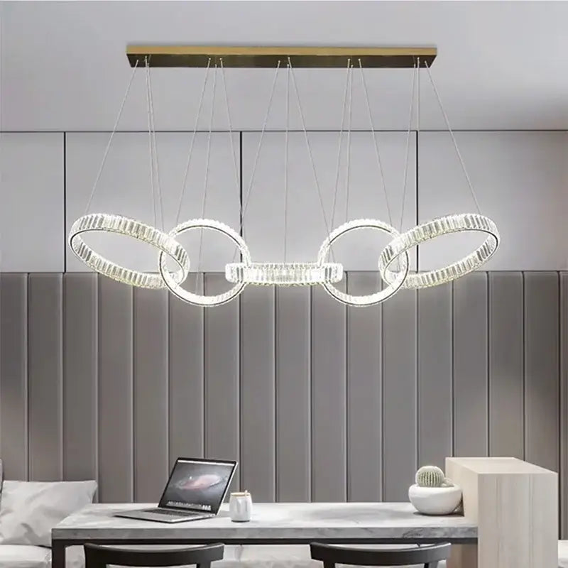 Modern geometric DecorBites crystal chandelier pendant light with interconnected crystal rings and brass ceiling mount