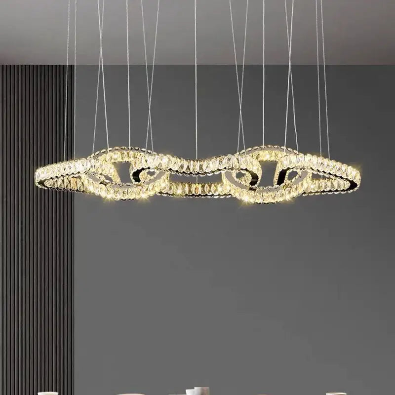 A decorbites crystal chandelier pendant light with interlocking crystal rings emitting warm light for living rooms