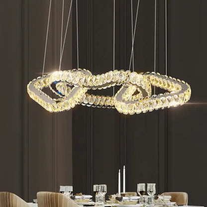 A modern decorbites crystal chandelier pendant light with double-looped crystal design and warm glowing lights for dining room