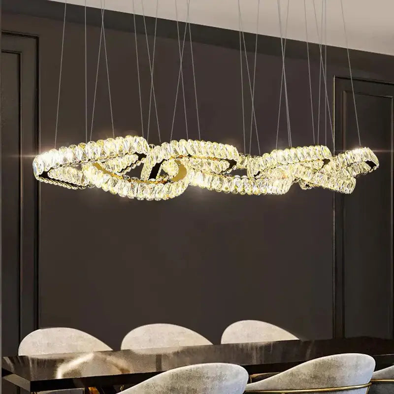 A modern gold-toned decorbites crystal chandelier pendant light with clear crystals for living and dining rooms