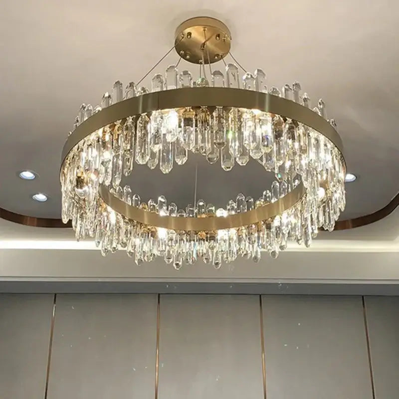 A modern decorbites crystal chandelier pendant light with gold metal rings and clear crystal droplets for luxury rooms