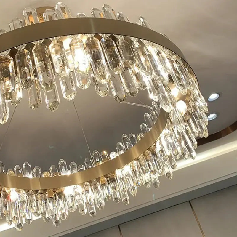 A modern decorbites crystal chandelier pendant light with clear prisms and gold-toned frame for luxury living spaces
