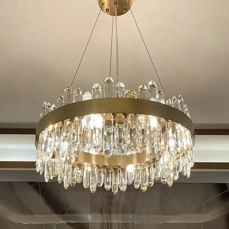 A modern two-tiered decorbites crystal chandelier pendant light with brushed gold frame and clear faceted crystals