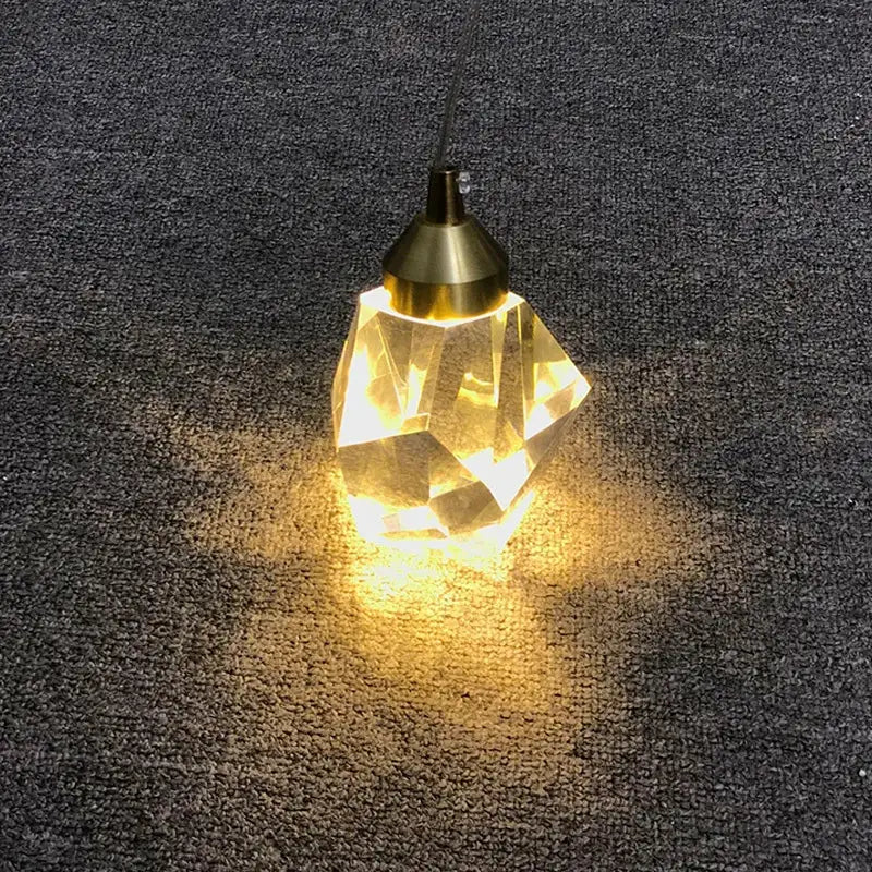 A warm faceted crystal chandelier pendant with brass finish and geometric design from decorbites for dining room lighting