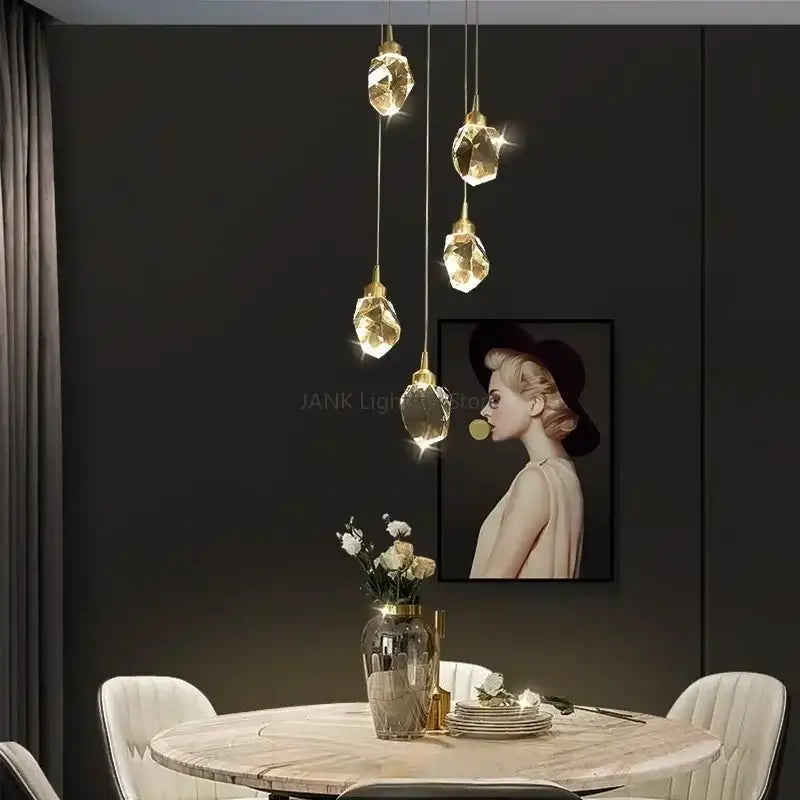 Five gold-finished decorbites crystal chandelier pendant lights with hanging crystals illuminate the dining area