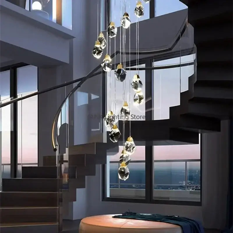 A modern gold-toned decorbites crystal chandelier pendant light elegantly hangs above a spiral staircase