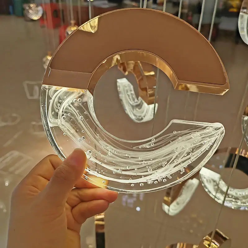 A translucent glass pendant light with rose gold frame and swirling patterns for DecorBites crystal chandelier ring