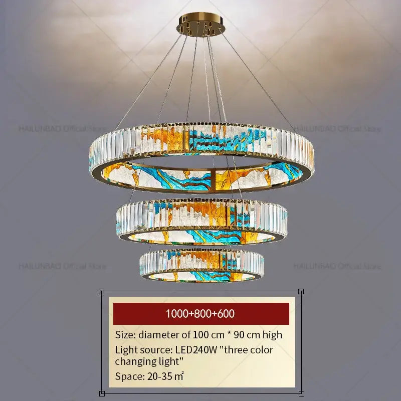 A modern decorbites crystal chandelier featuring cascading clear crystal rings and blue gold white stained glass panels