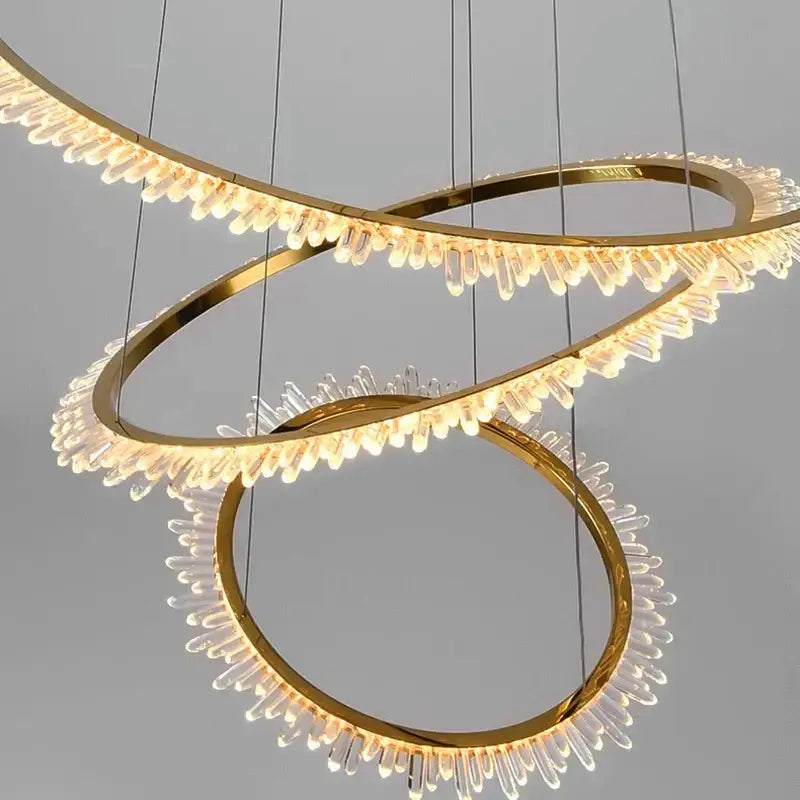 Gold-toned decorbites crystal chandelier with three interlocking rings and clear crystal droplets for modern living rooms