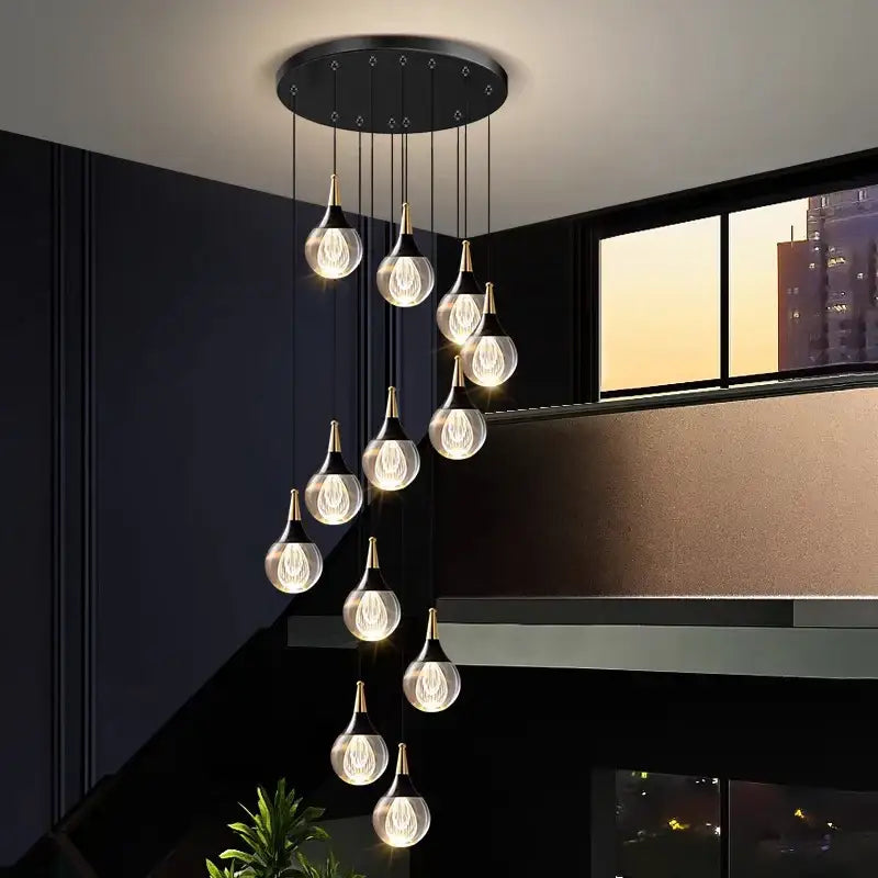 Modern black circular DecorBites™ crystal chandelier stair pendant with ten gold-topped teardrop glass stair pendant lamps