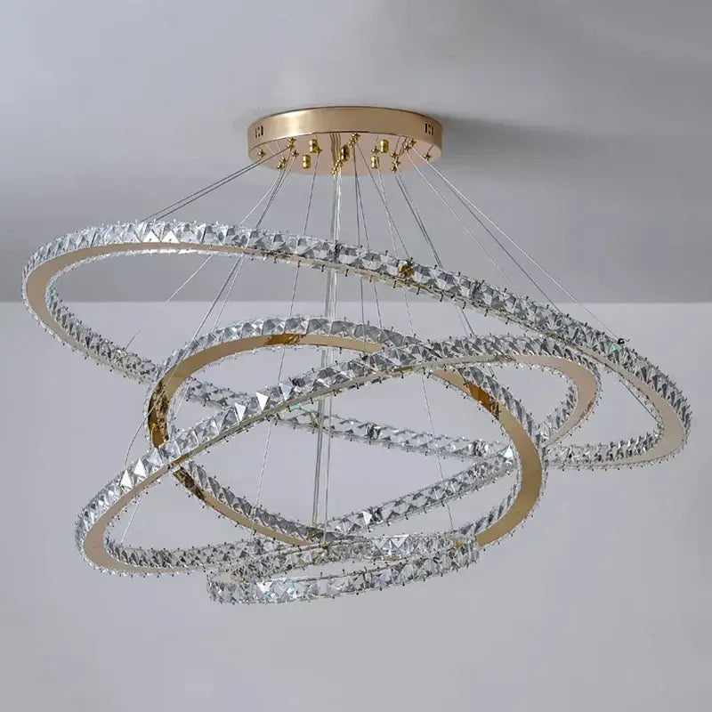 A modern decorbites crystal chandelier with gold-toned rings and clear crystals for living room lighting