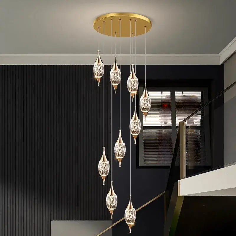 Gold-toned decorbites crystal chandelier with crystal-encrusted teardrop lamps suspended from a circular ceiling mount