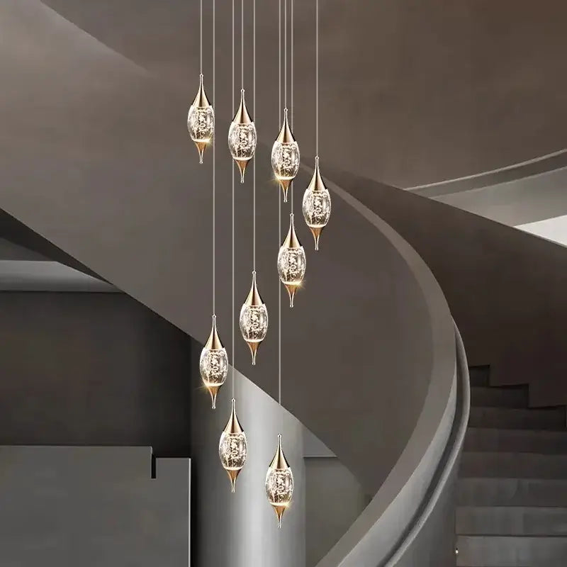Elegant gold-toned decorbites crystal chandelier with crystal-encrusted teardrop shades in modern staircase lighting