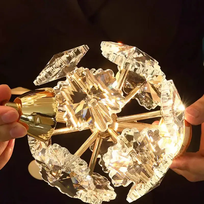 A golden decorbites crystal chandelier pendant lamp with intricate faceted crystal prisms for stair lighting
