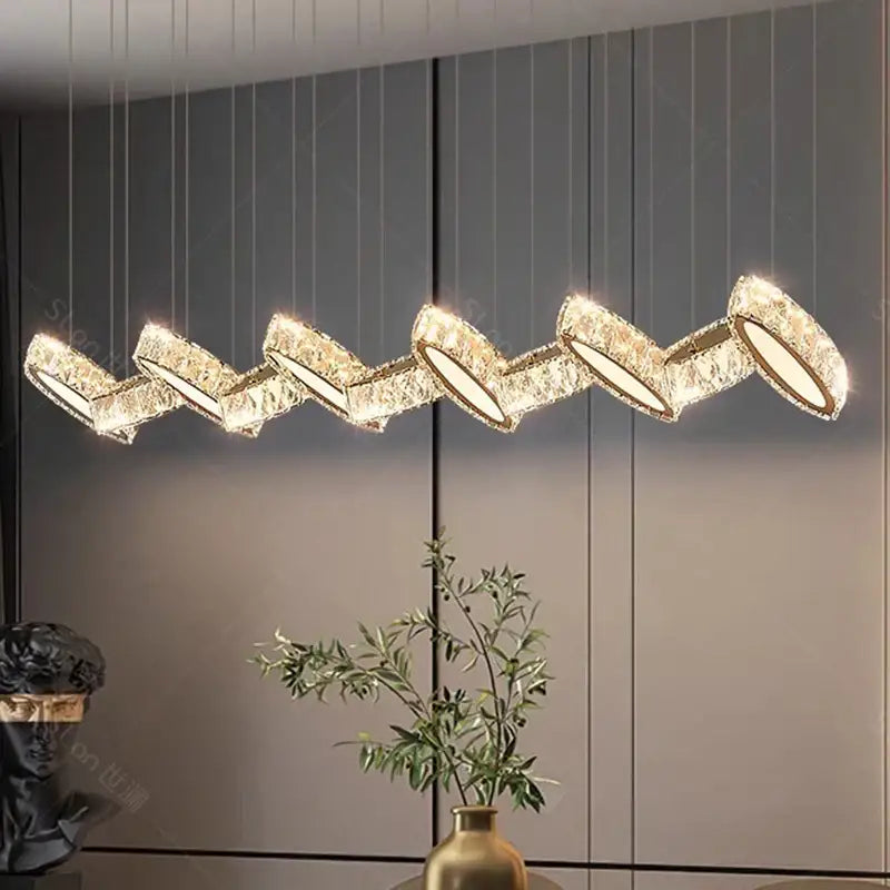 Gold-toned crystal chandelier stair pendant with zigzag design by DecorBites for modern living room lighting