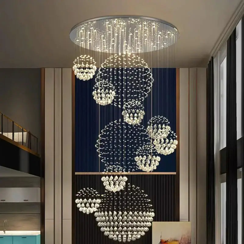 A modern decorbites crystal chandelier with cascading crystal spheres on a metallic frame for stair pendant lighting
