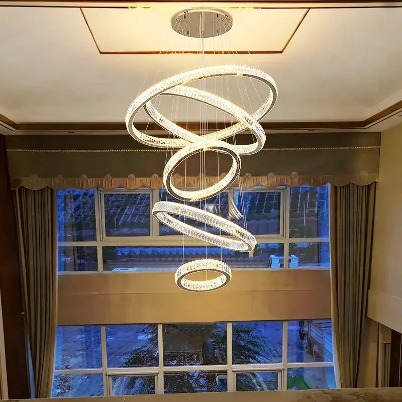 A modern decorbites crystal chandelier with glowing spiral rings made of clear crystal and metal for living room lighting