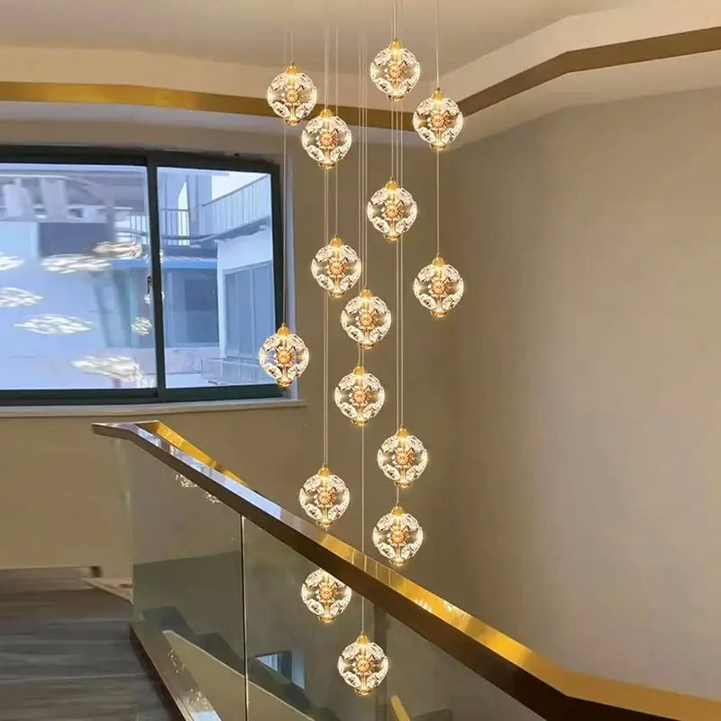 A modern DecorBites crystal chandelier stair pendant lamp with spherical crystal pendants and gold-toned metalwork