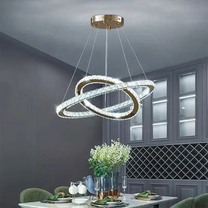 A modern gold-toned decorbites crystal chandelier with two interlocking crystal rings for living room lighting