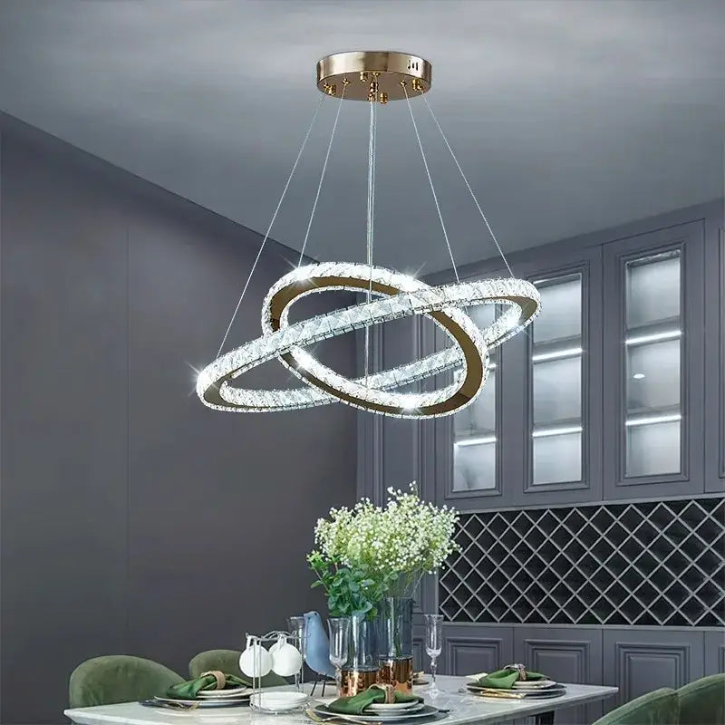 A modern gold-toned decorbites crystal chandelier with two interlocking crystal rings for living room lighting