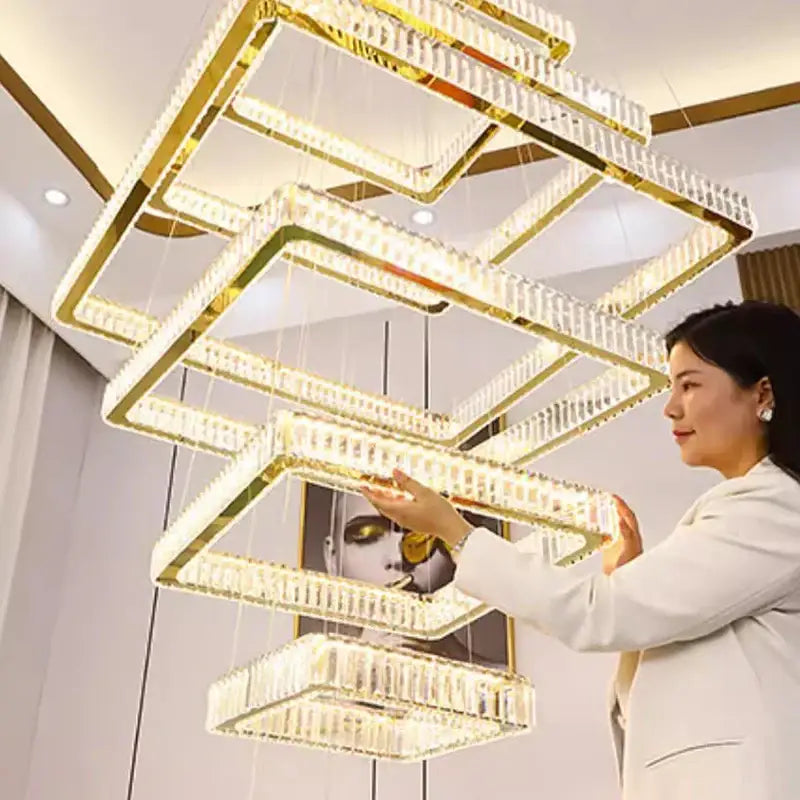 Multi-tiered gold finished decorbites crystal chandelier stair pendant lamp with clear crystal accents and warm glow