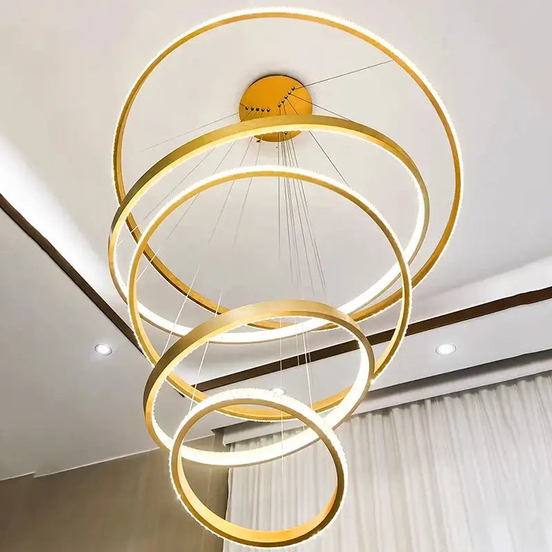 Modern gold-toned DecorBites crystal chandelier stair pendant lamp with illuminated circular rings in cascading spiral design