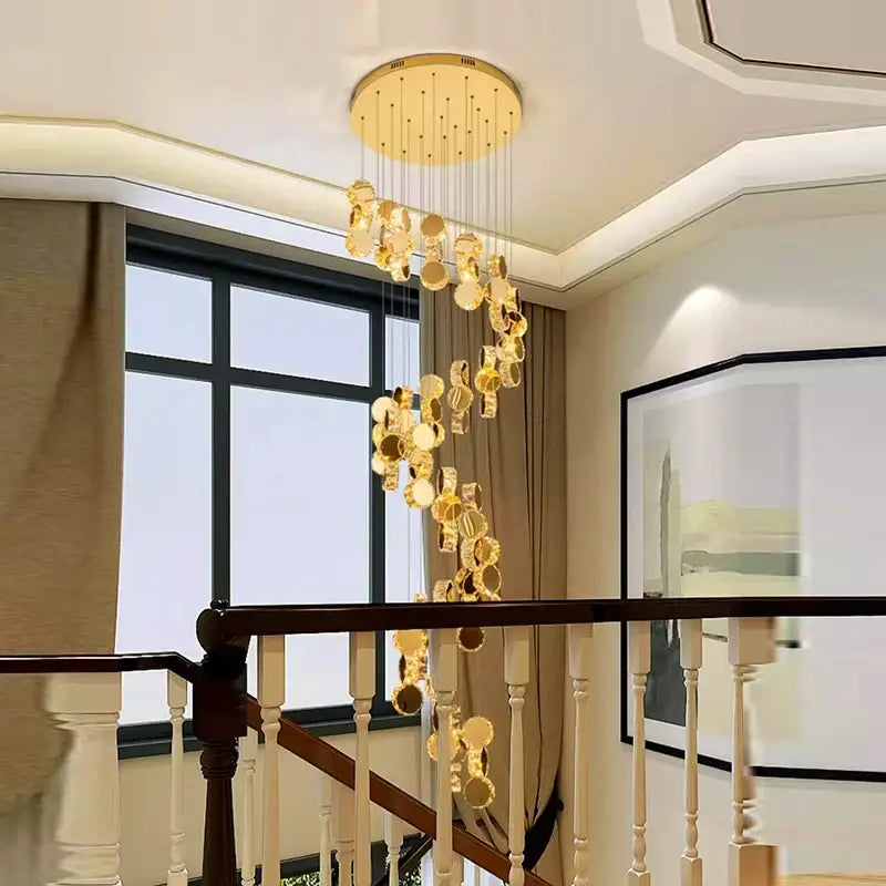 Golden decorbites crystal chandelier with cascading crystal discs and polished brass fixture ideal for stair pendant lighting