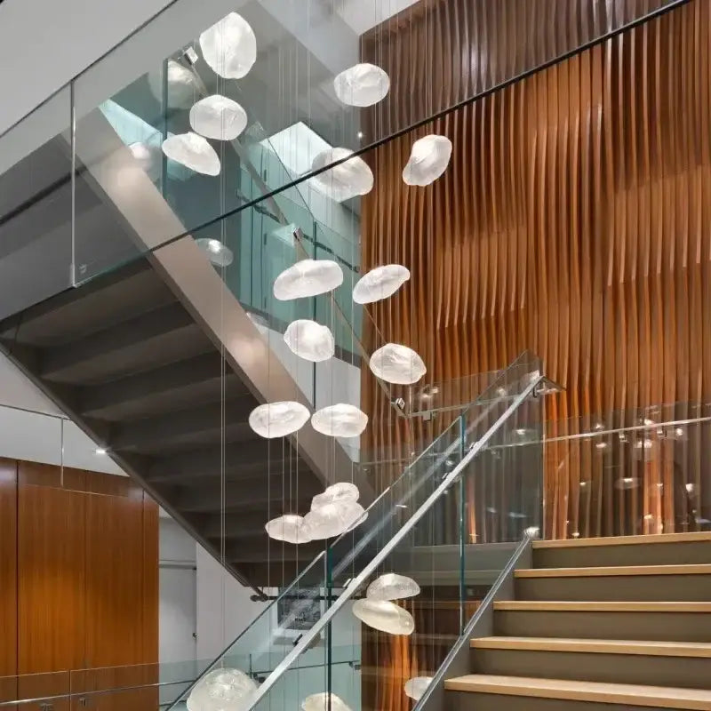 A modern decorbites crystal chandelier stair pendant featuring cascading translucent cloud-like glass orbs