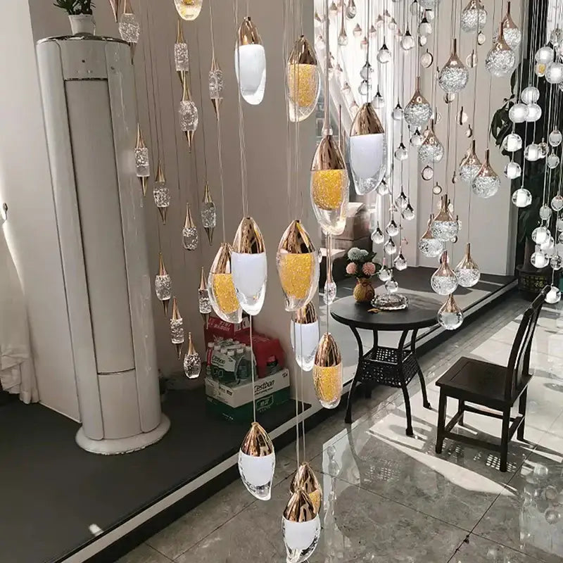 Decorbites crystal chandelier with cascading teardrop glass pendants in clear, frosted white, and golden glitter for living room lighting
