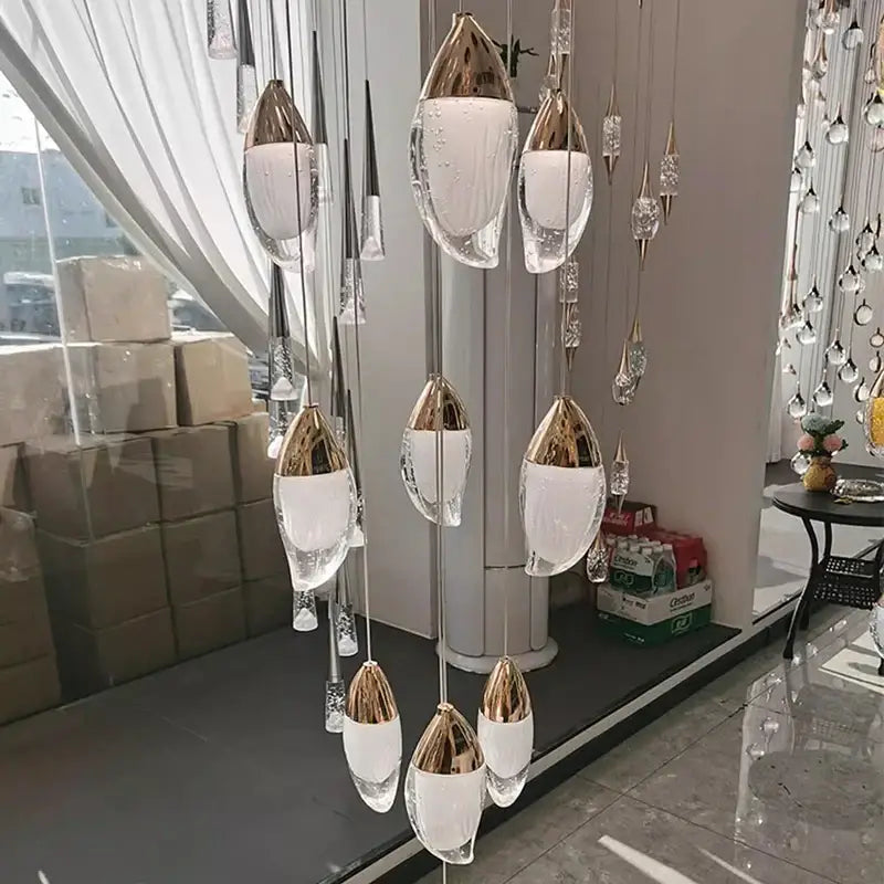 Decorbites crystal chandelier featuring modern teardrop clear glass pendant lights with gold-toned metal accents for living room lighting