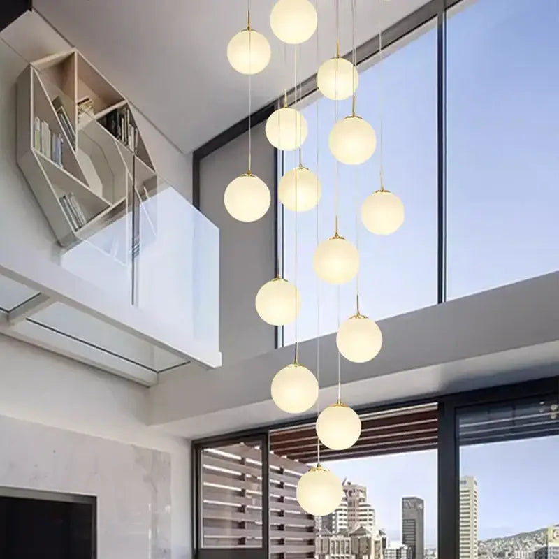 A modern DecorBites crystal chandelier stair pendant light with spherical glass globes and gold-toned chains