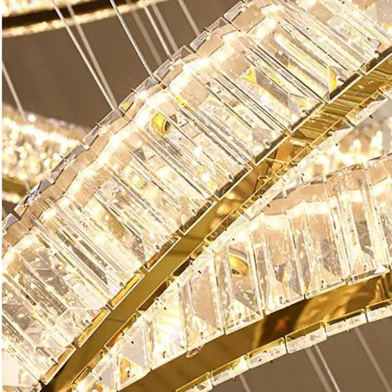 A DecorBites crystal chandelier stair pendant with cascading clear crystal prisms and a polished gold metal frame