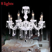 Elegant white DecorBites crystal chandelier with eight lit LED candle lights and dangling teardrop crystals for living rooms