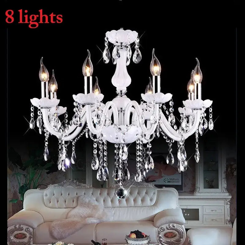 Elegant white DecorBites crystal chandelier with eight lit LED candle lights and dangling teardrop crystals for living rooms