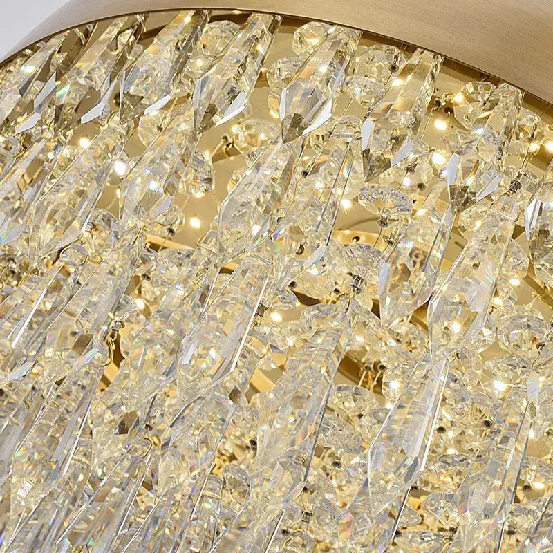 A luxurious decorbites crystal copper pendant light with cascading clear prisms and warm gold-toned metal frame