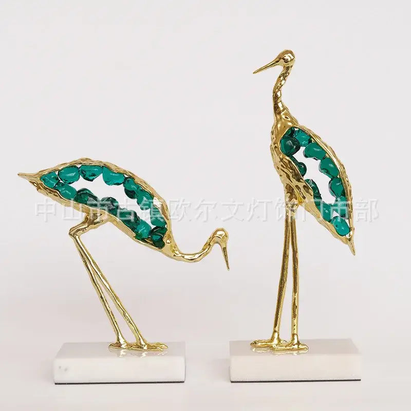 Golden decorbites crystal crane sculpture with teal gemstone wings on white marble bases for elegant living room decor