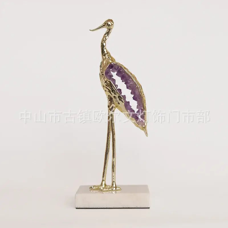 Golden crystal crane sculpture with purple amethyst geode wing on white marble base by decorbites crystal crane