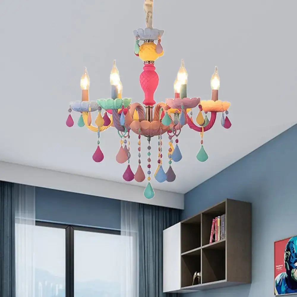 A vibrant decorbites™ crystal decorated kids chandelier with a pink central body and pastel teardrop glass ornaments