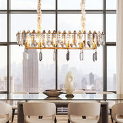 Gold-toned DecorBites™ crystal drop island lighting with modern clear oval design and smoky crystal accents for dining hall