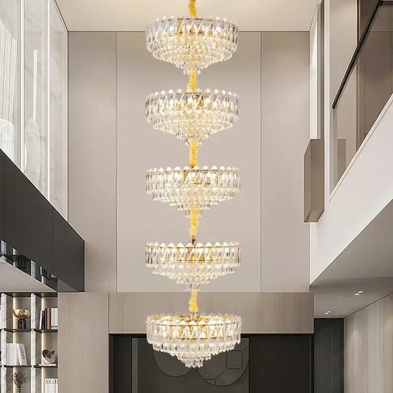 A multi-tiered decorbites crystal duplex chandelier with a golden frame and clear glass prisms for living room lighting