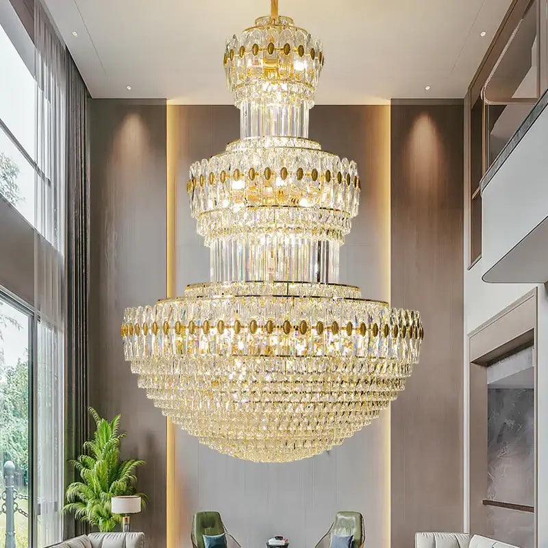 A multi-tiered decorbites crystal duplex gold chandelier with cascading clear crystals for hotel and living room use