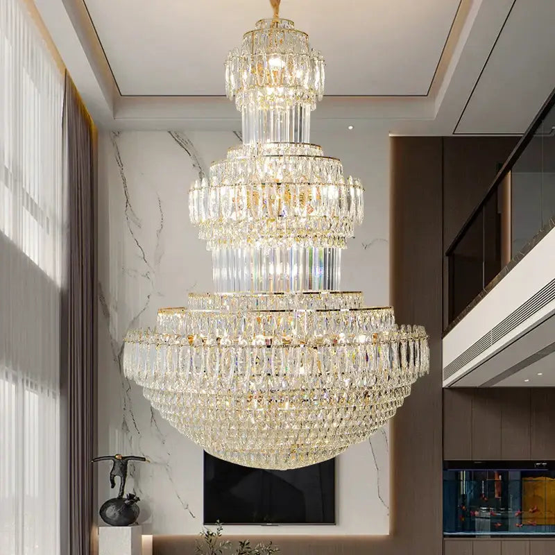 A multi-tiered decorbites crystal duplex gold chandelier with cascading clear crystals for hotel and living room use