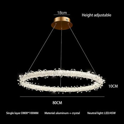 A decorbites crystal flower led chandelier with gold mount and clear crystals emitting neutral LED light for dining rooms
