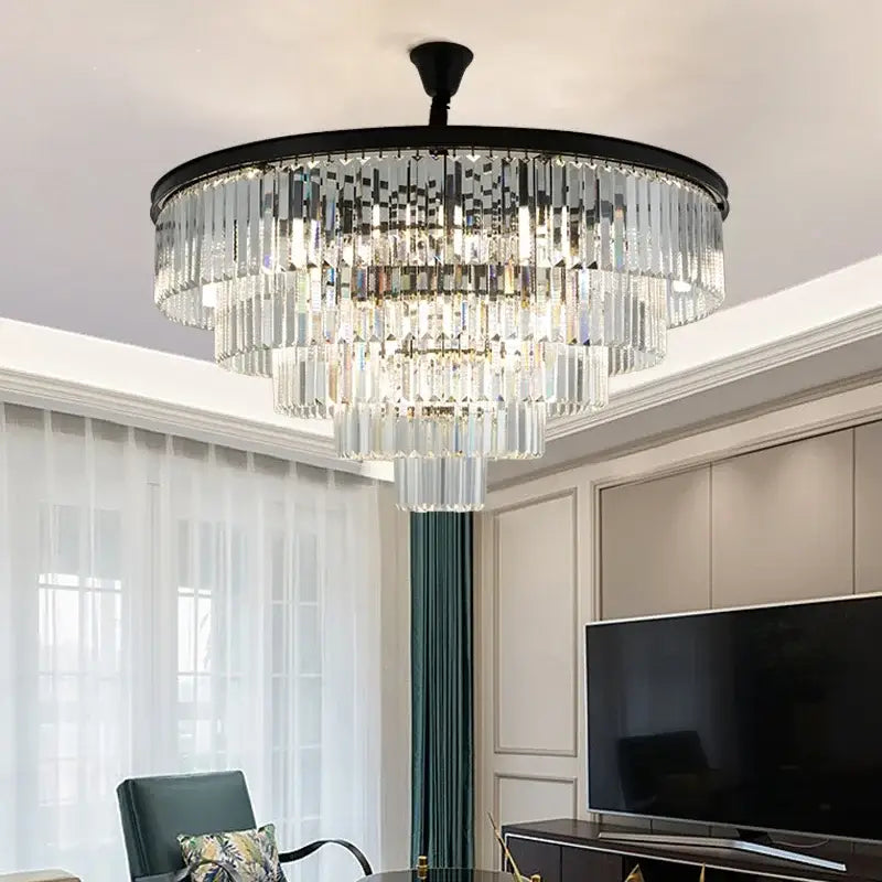 A multi-tiered decorbites crystal gold chandelier with black metal frame and clear glass prisms for living room light