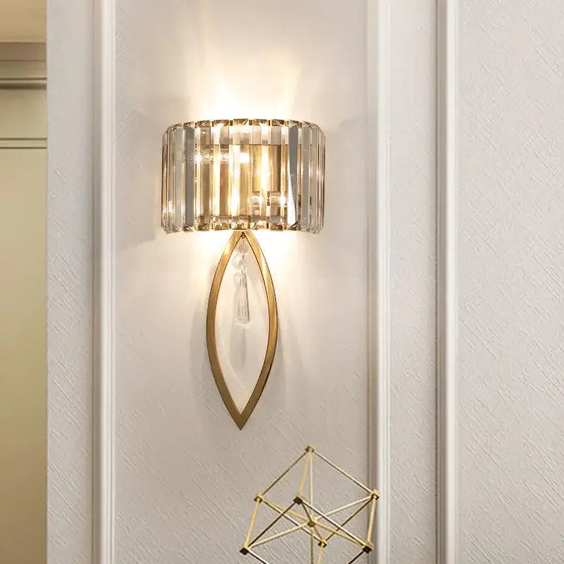 Gold-toned decorbites crystal led black wall lamp with cylindrical crystal shade and teardrop frame for bedroom